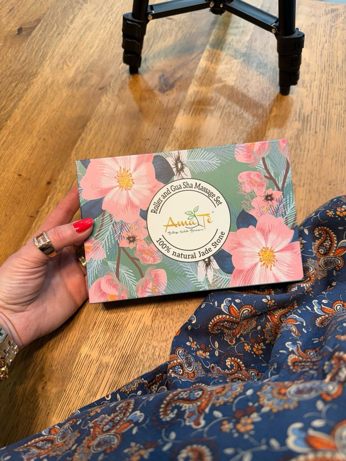 Confezione del set massaggio con rullo e Gua Sha in giada. Motivo floreale e logo AMATÈ. Testo: 100% pietra di giada naturale.