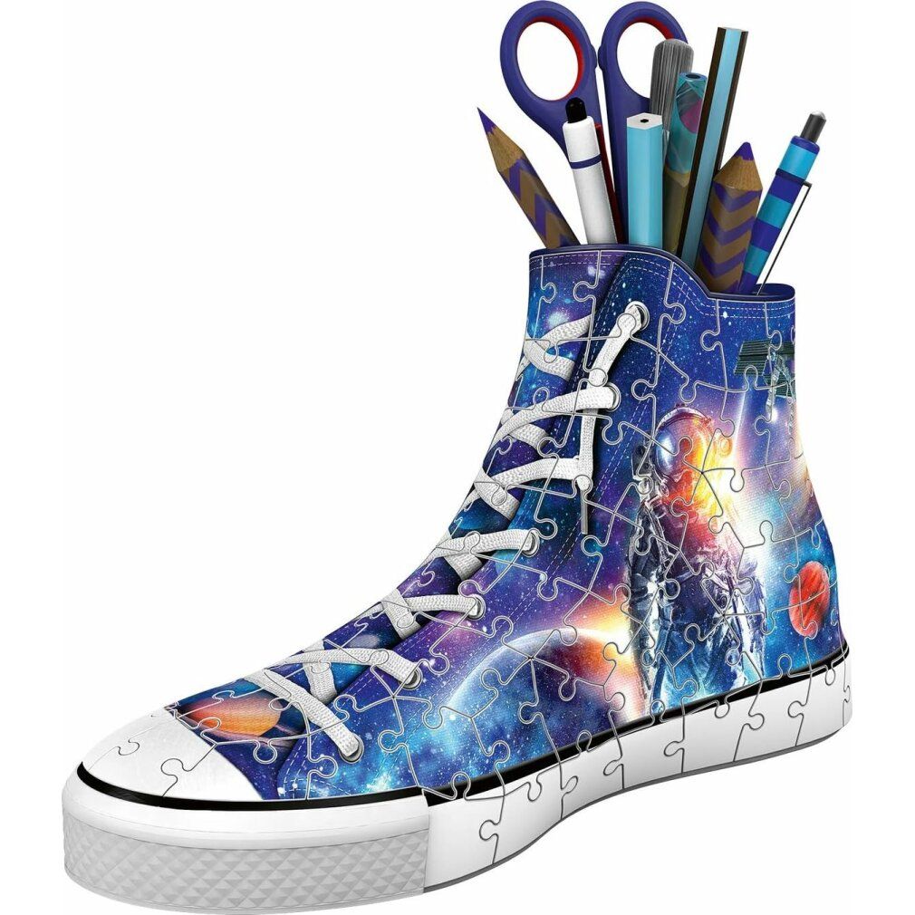 Puzzle 3D Sneaker Galaxy, a forma di scarpa, riempito di penne. Pezzi del puzzle con design spaziale. Lacci e suola bianchi.