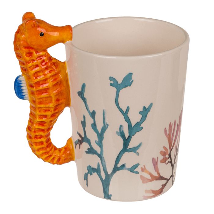 Tazza con manico a forma di cavalluccio marino. Bianca, con motivi corallini blu e rossi. Il manico è un cavalluccio marino arancione.