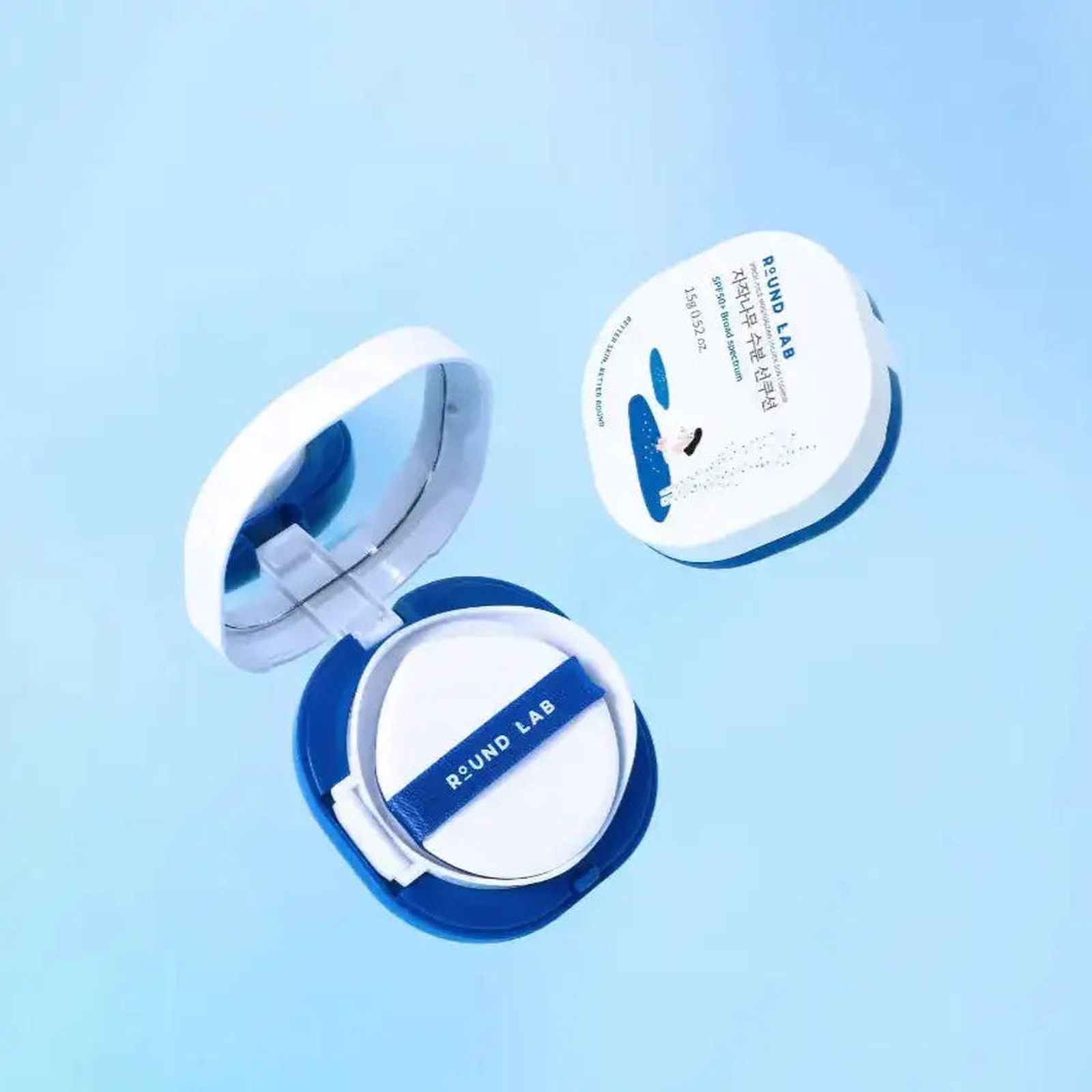 Cuscino solare Round Lab aperto con spugnetta bianca e specchio. Contenitore blu e bianco.