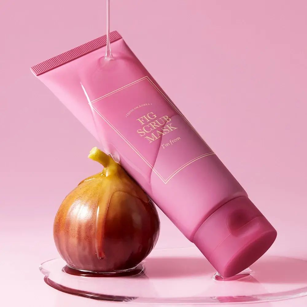 Tubo rosa con nome del prodotto e fico. Liquido che scorre su fico e tubo. I'M FROM Fig Scrub Mask.
