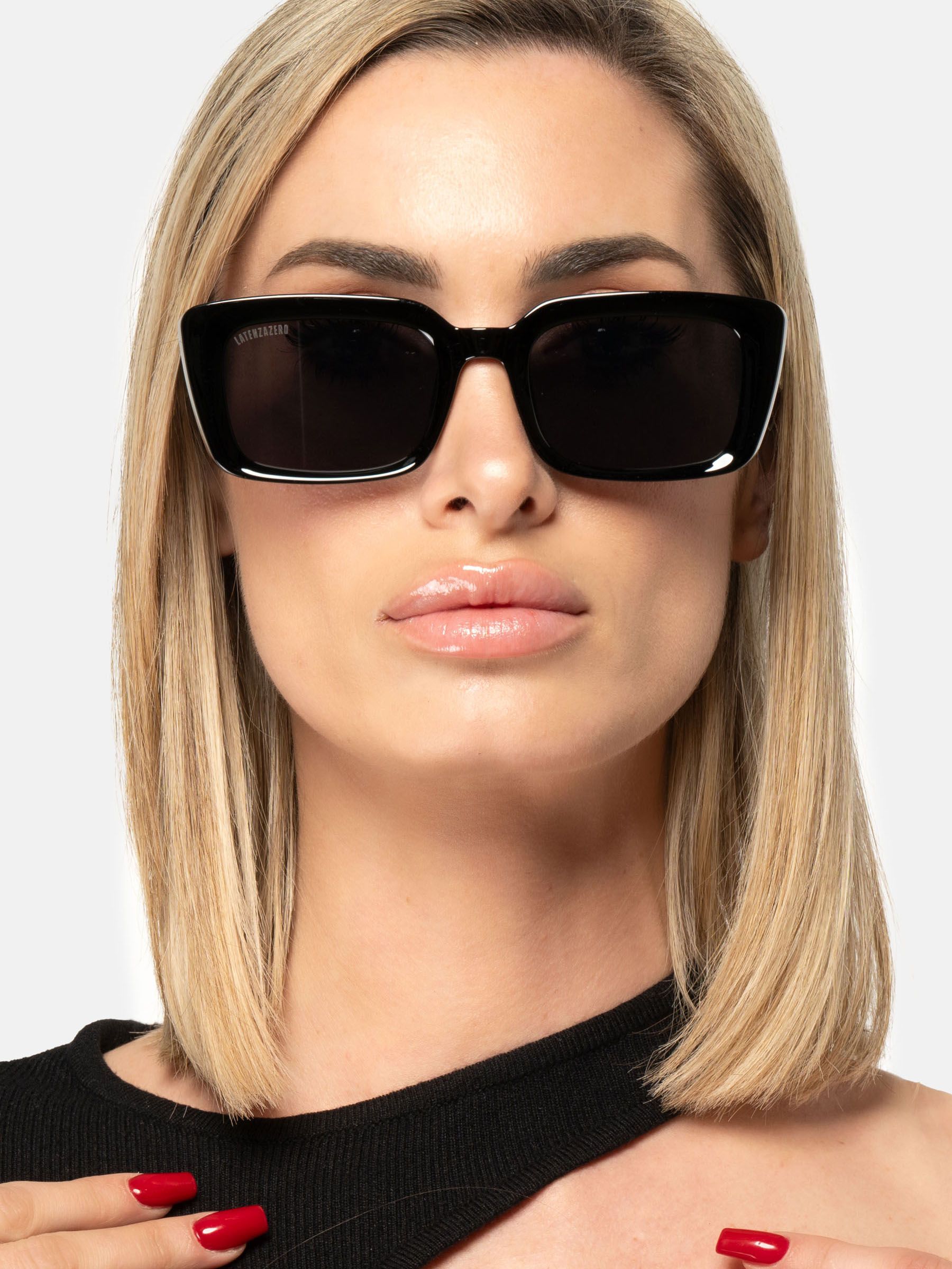 Donna con occhiali da sole neri con lenti rettangolari. Latenzazero sull'asta.