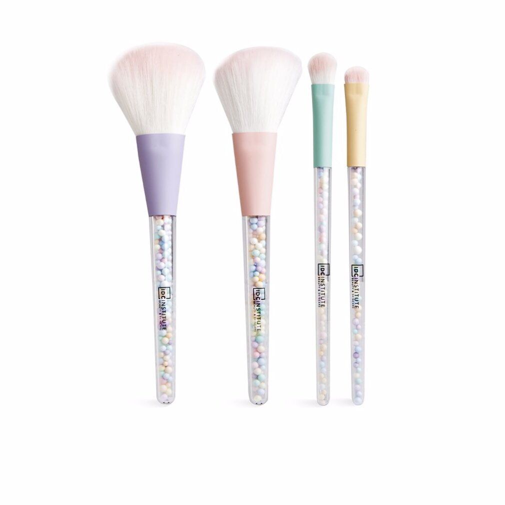 Quattro pennelli per trucco con manici pastello e steli trasparenti con perline colorate. Teste dei pennelli bianche.