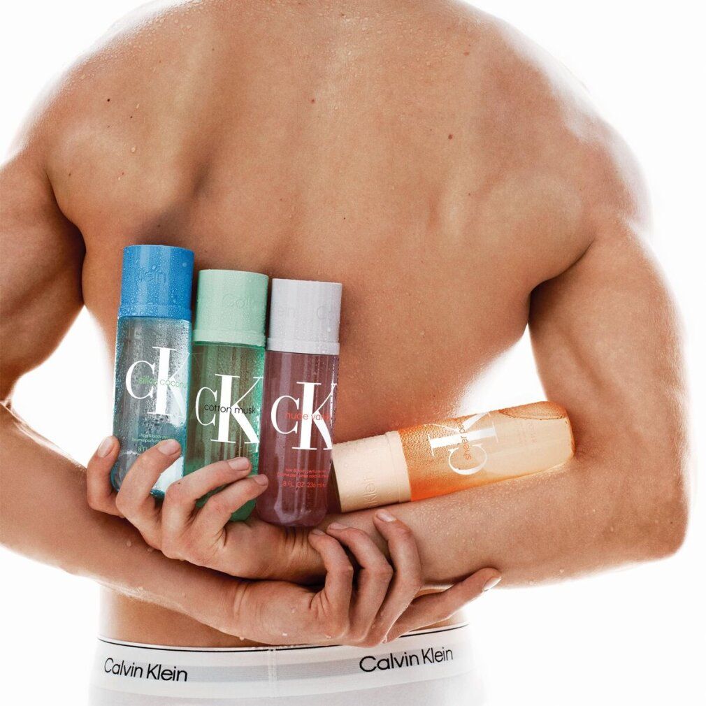 Uomo tiene quattro flaconi. Scritta "Calvin Klein". Flaconi blu, verdi, bianchi e arancioni. L'uomo indossa biancheria intima con logo.