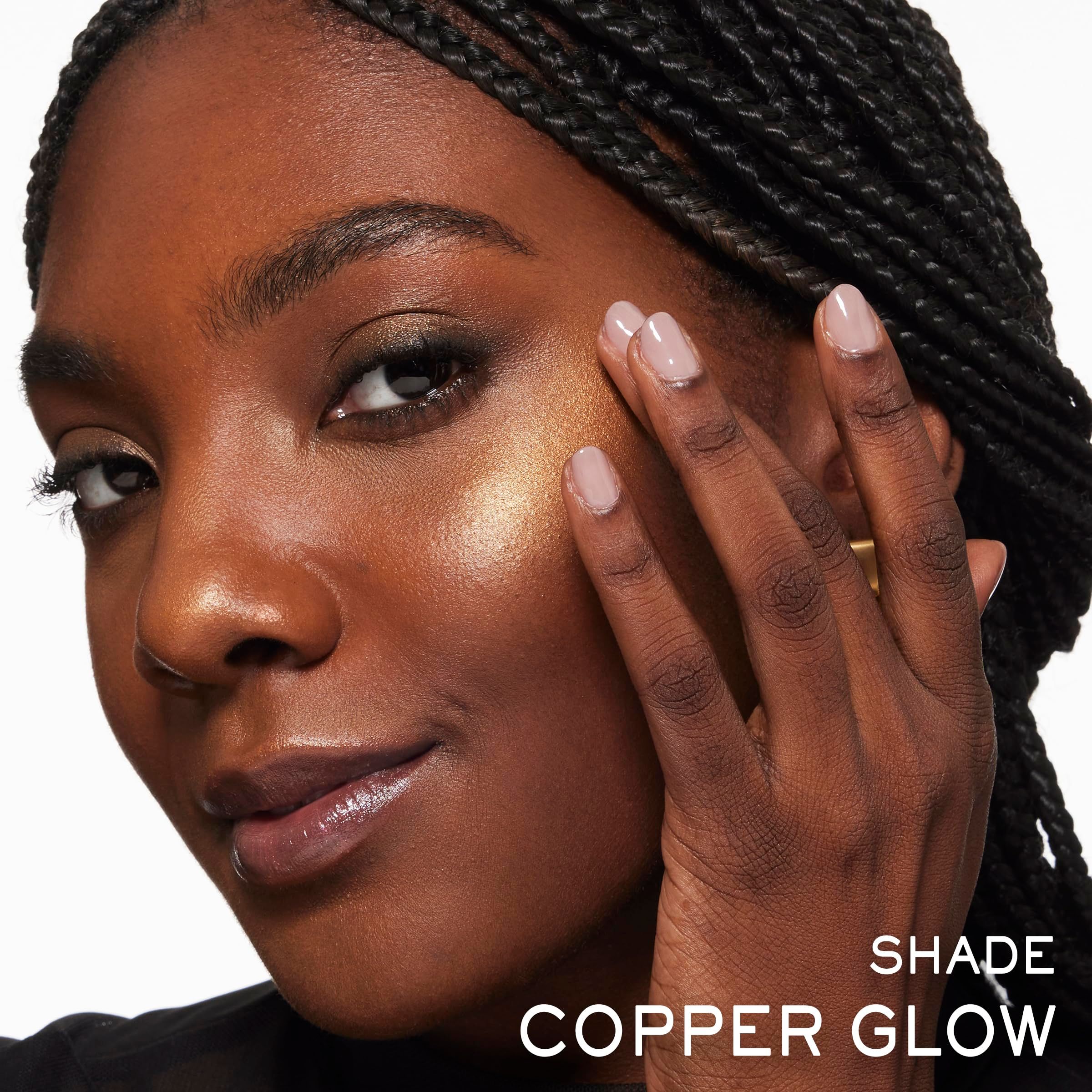 Ritratto di una donna con pelle scura. Prodotto applicato sul viso. Testo: COPPER GLOW.