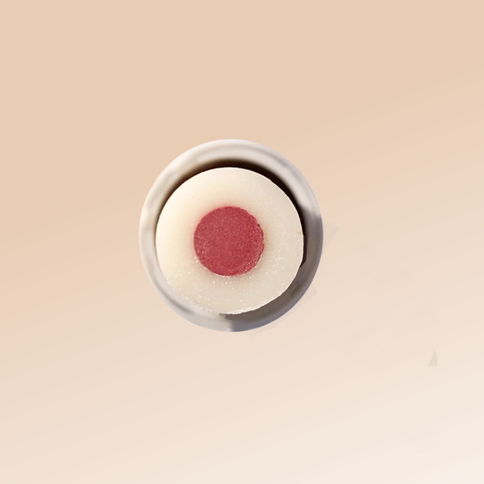 Vista dall'alto di uno stick labbra. Bordo bianco, cuore rosso. Custodia trasparente.