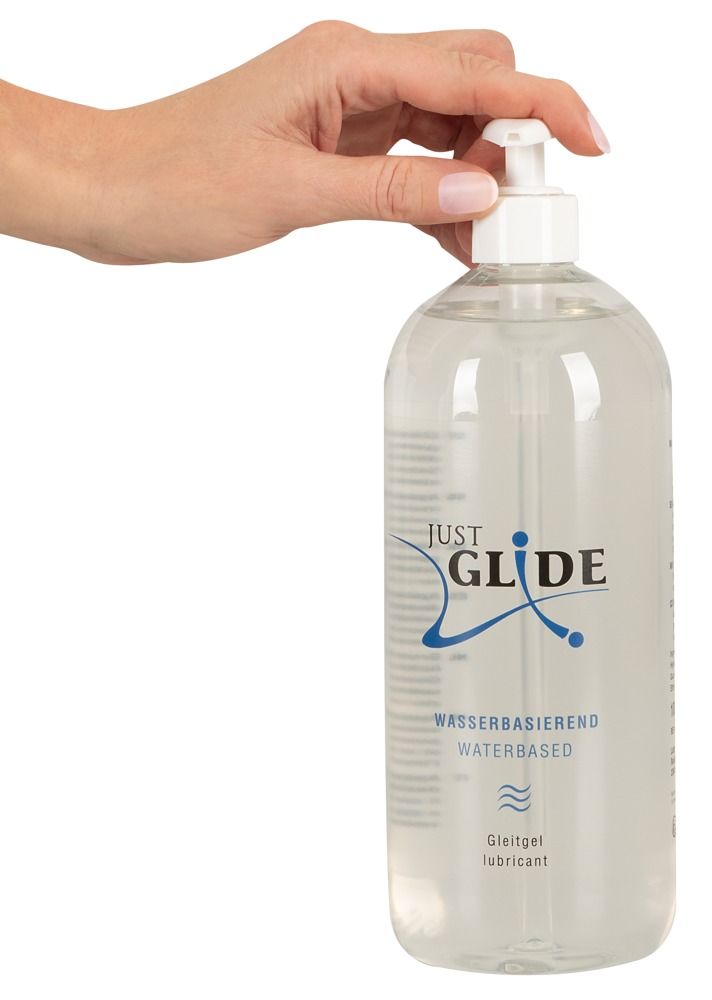Mano aziona il dosatore di un flacone trasparente. Scritta: JUST GLIDE, a base d'acqua, gel lubrificante medico.