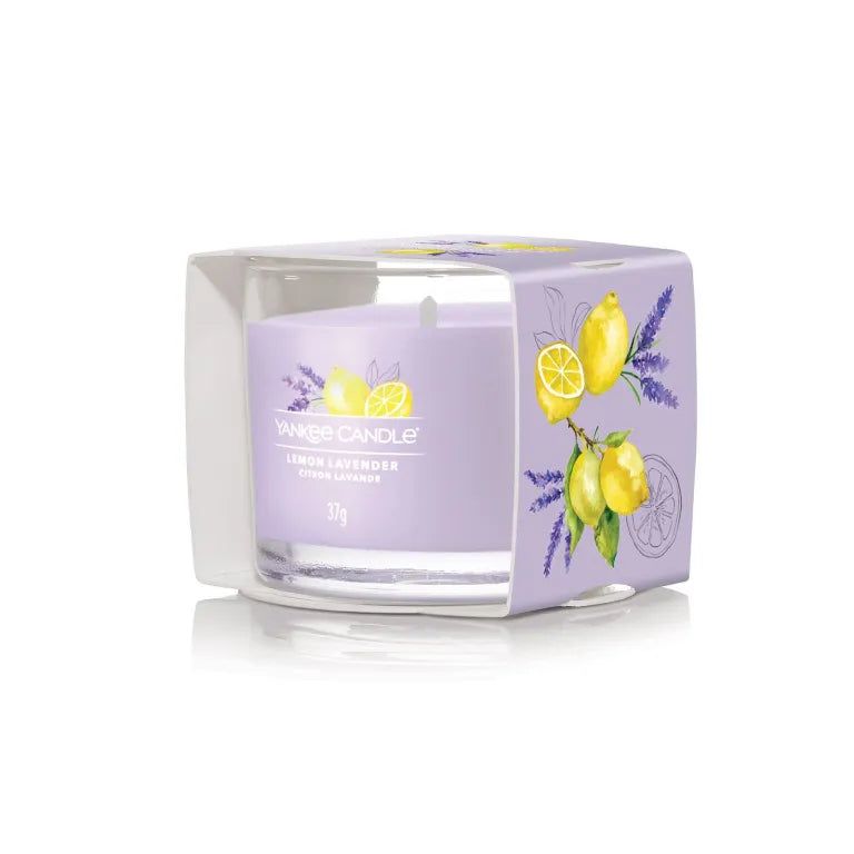 Candela profumata in vetro nella confezione. Cera lilla con stampa limone e lavanda. Scritta: Lemon Lavender, Citron Lavande, 37g.