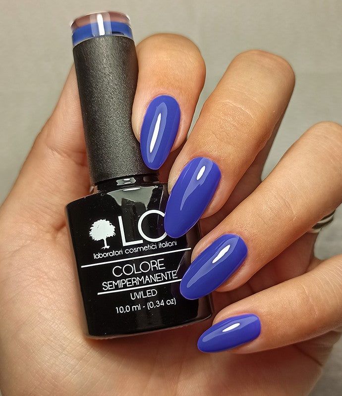Mano con unghie smaltate e flacone di smalto. Scritta: LCI, Colore Semipermanente, UVLED 10,0 ml.