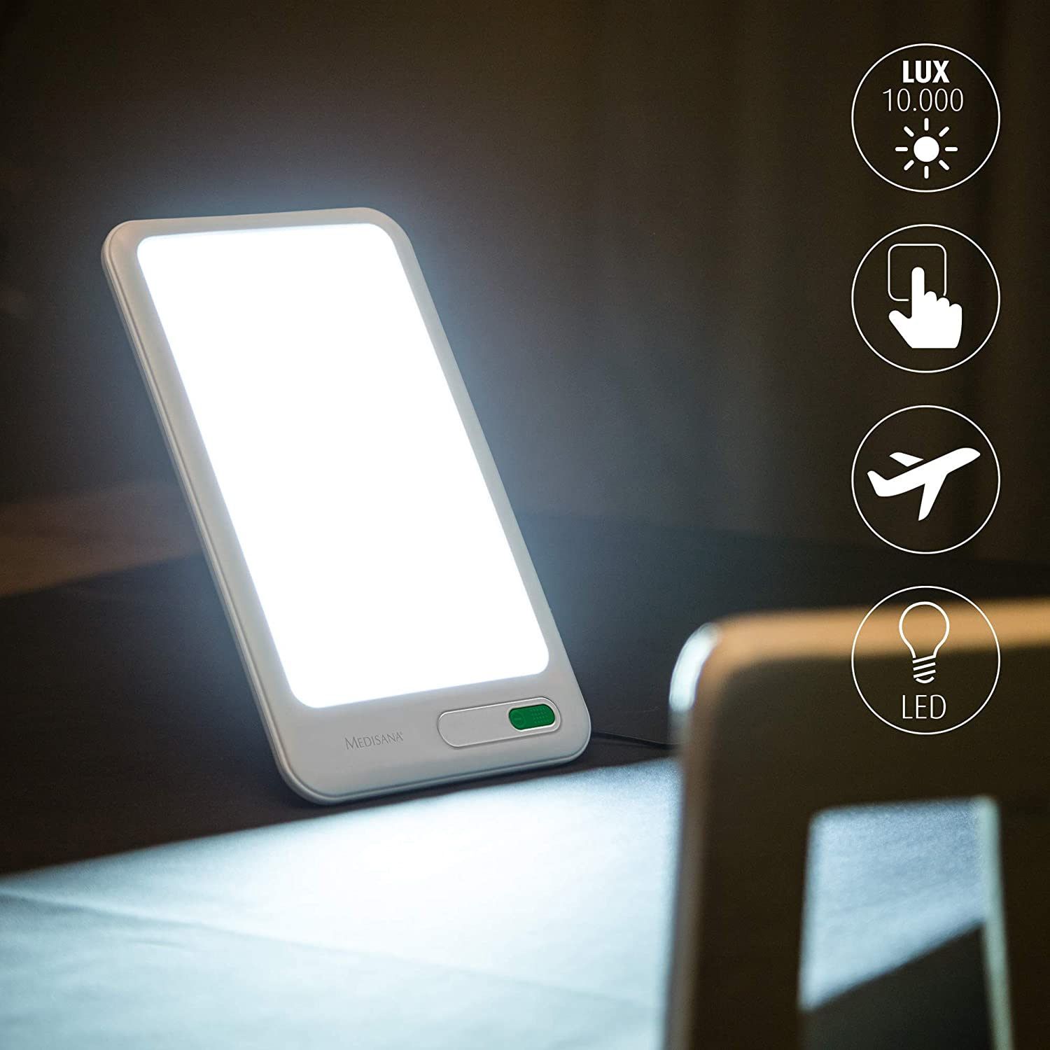 Dispositivo bianco rettangolare con angoli arrotondati. Pulsante verde in basso. Simboli: sole, tocco, aereo, LED.