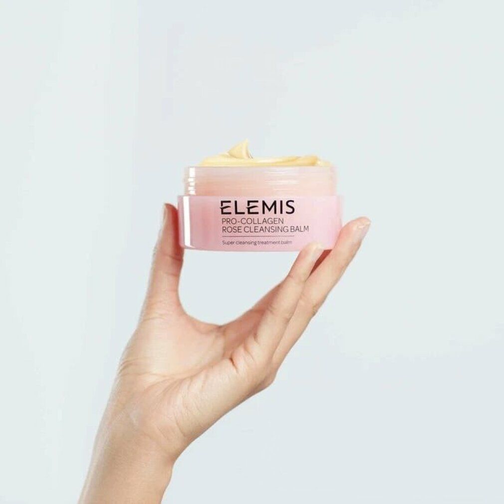 Mano che tiene un vasetto rosa con balsamo giallo. Scritta: Elemis Pro-Collagen Rose Cleansing Balm. Testo: Super cleansing treatment balm.