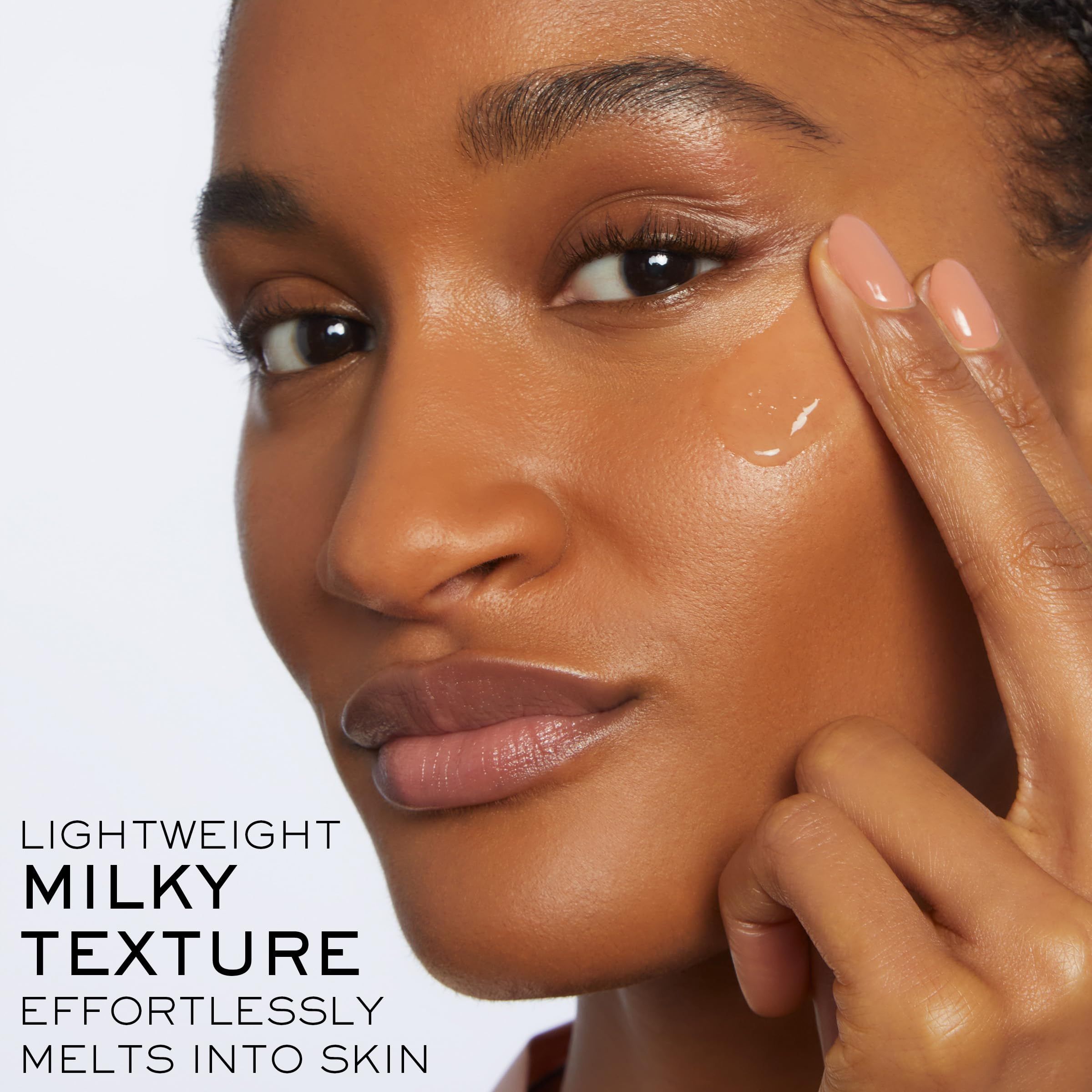 Donna tocca il viso. Testo: La texture leggera e lattiginosa si scioglie senza sforzo sulla pelle.