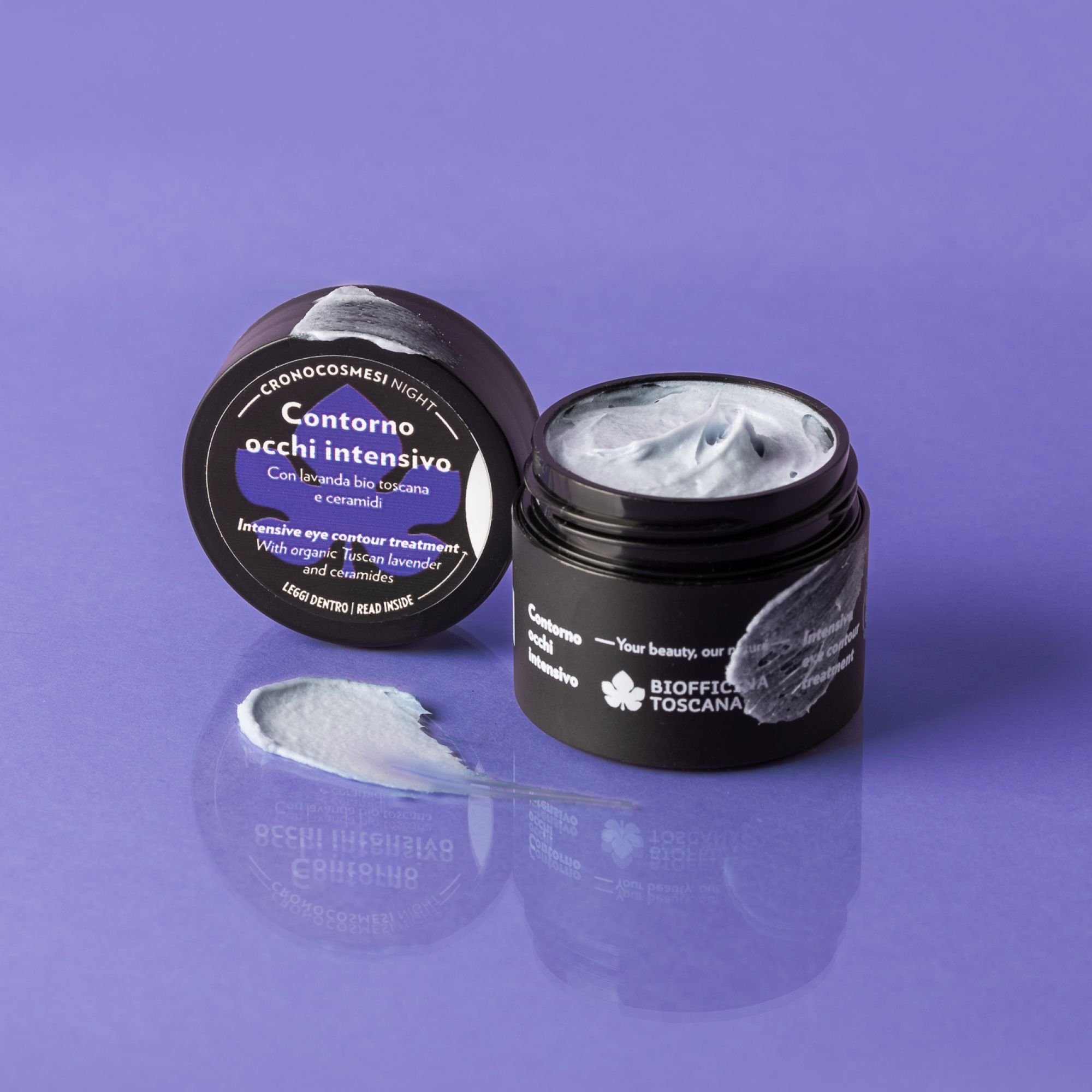 Vaso nero con crema, accanto il coperchio e una macchia di crema. Sul coperchio, "Contorno occhi intensivo".