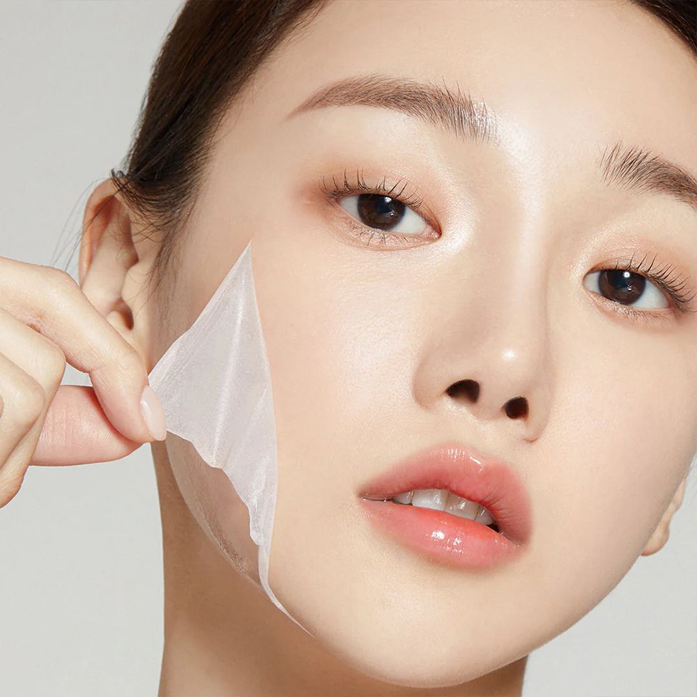 Una donna rimuove la 'Collagen Night Wrapping Mask' secca dal viso.