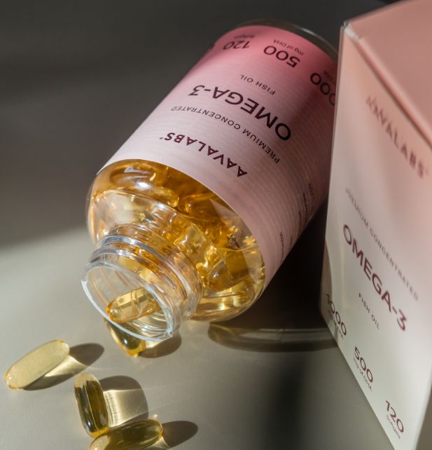 Flacone di olio di pesce Omega-3 Aavalabs con capsule molli versate e scatola.
