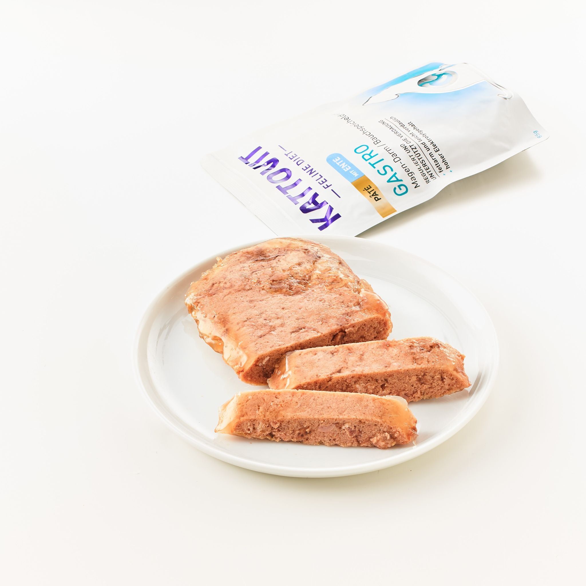 KATTOVIT Gastro Paté Ente su un piatto. Confezione aperta accanto. Cibo modellato tagliato a fette.