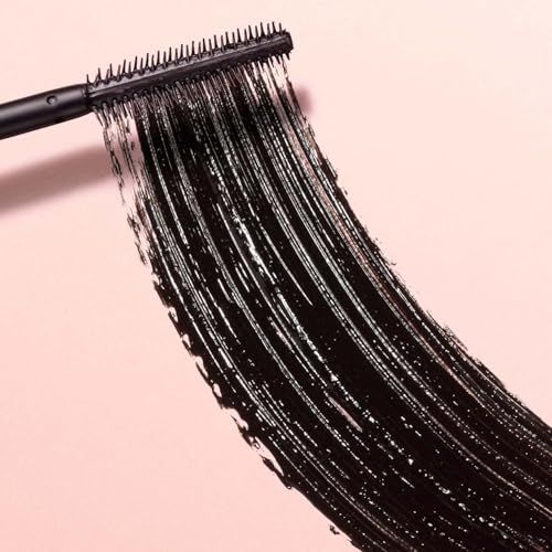 Spazzola per mascara nera con traccia di mascara nero su sfondo rosa.