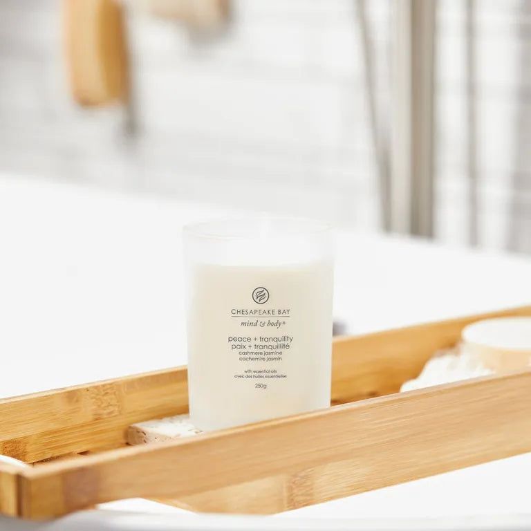 Candela Chesapeake Bay, mind & body, peace + tranquility. Su vassoio in legno in bagno. Con scritta.