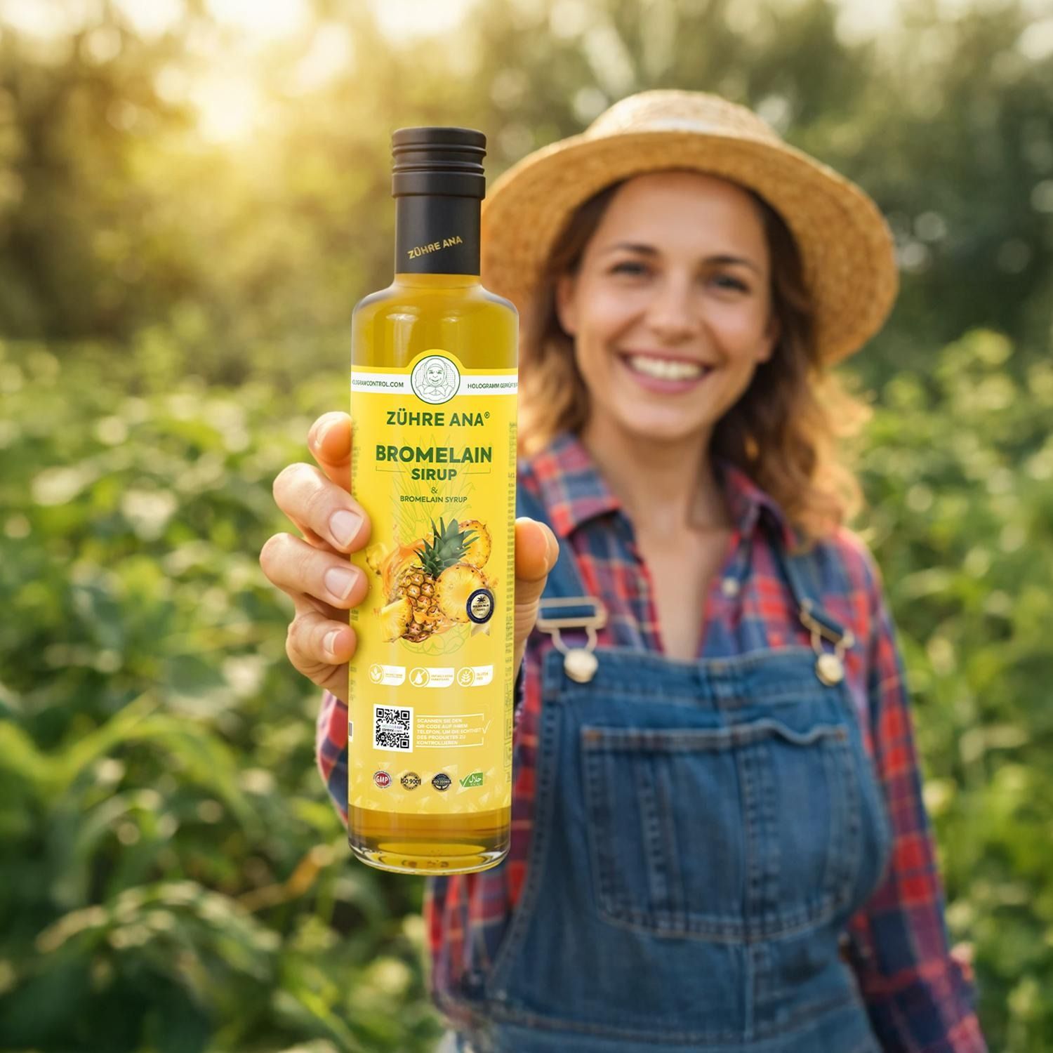 Donna con cappello di paglia tiene bottiglia di sciroppo di bromelina Zühre Ana in un campo.