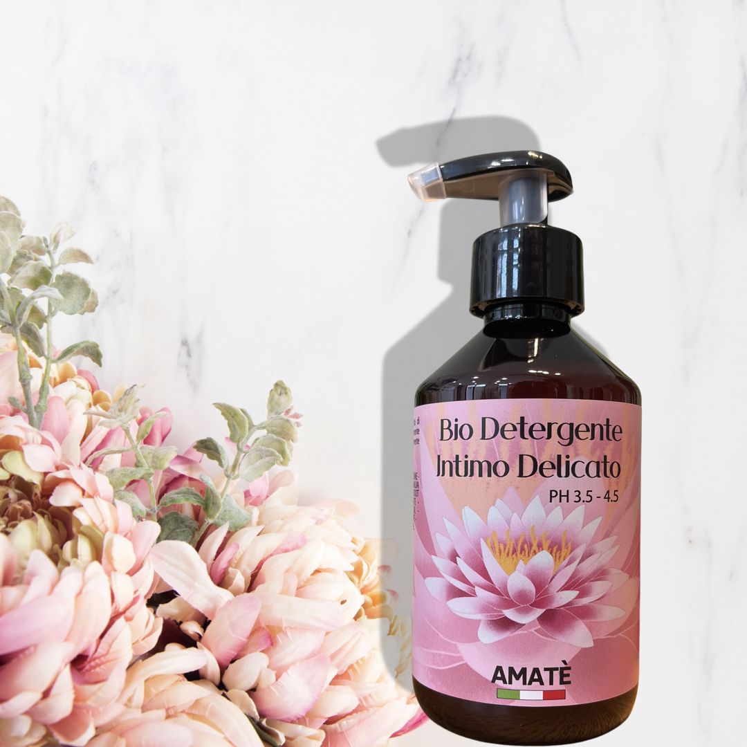 Flacone marrone con dosatore. Scritta: Bio Detergente Intimo Delicato, PH 3.5-4.5. Logo: AMATÈ. Fiore di loto rosa.