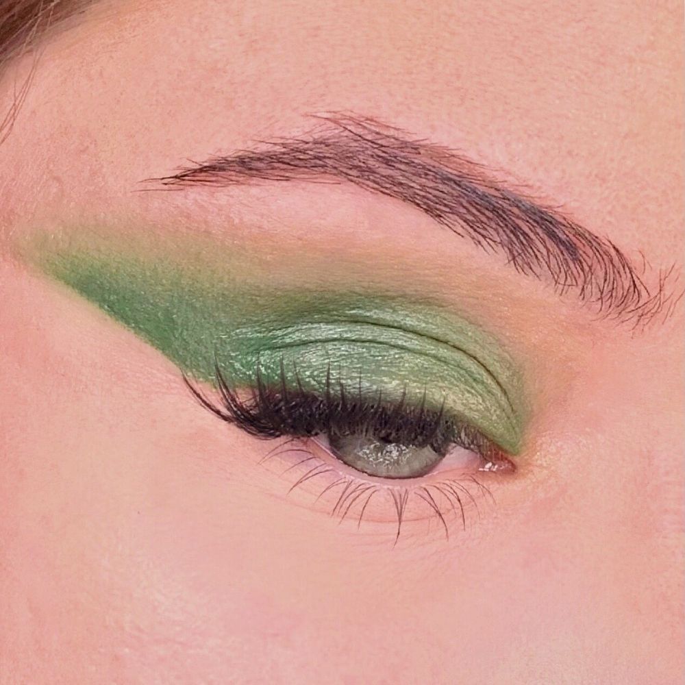 Ombretto verde applicato su un occhio. Palpebra e piega palpebrale evidenziate. Ciglia e sopracciglia visibili.
