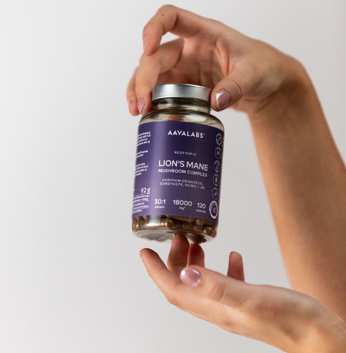 Mani che presentano una bottiglia di capsule Aavalabs Lion's Mane.