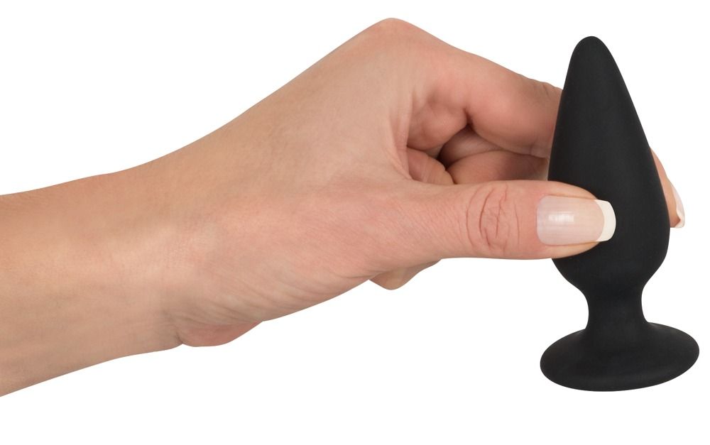 Plug anale nero con base, tenuto in mano. Punta conica, base rotonda.