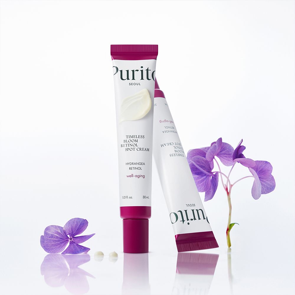 Due tubi di crema PURITO Timeless Bloom Retinol Spot Cream con fiori.