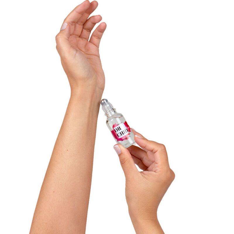 Mani che tengono un flacone roll-on trasparente. La sfera viene applicata sul polso. L'etichetta dice "ORCHID".