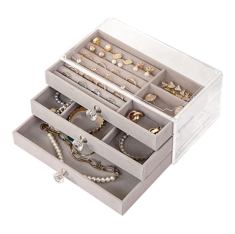 Quattro beauty case trasparenti di varie dimensioni uno accanto all'altro.