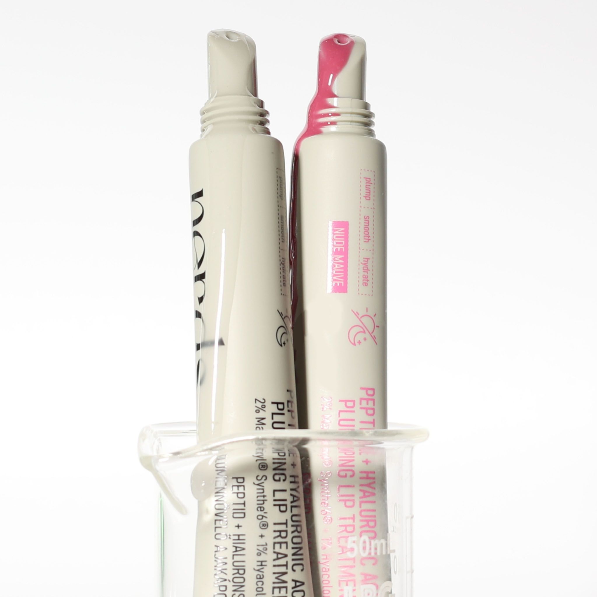 Due tubetti di trattamento labbra, uno con texture rosa e uno bianca.