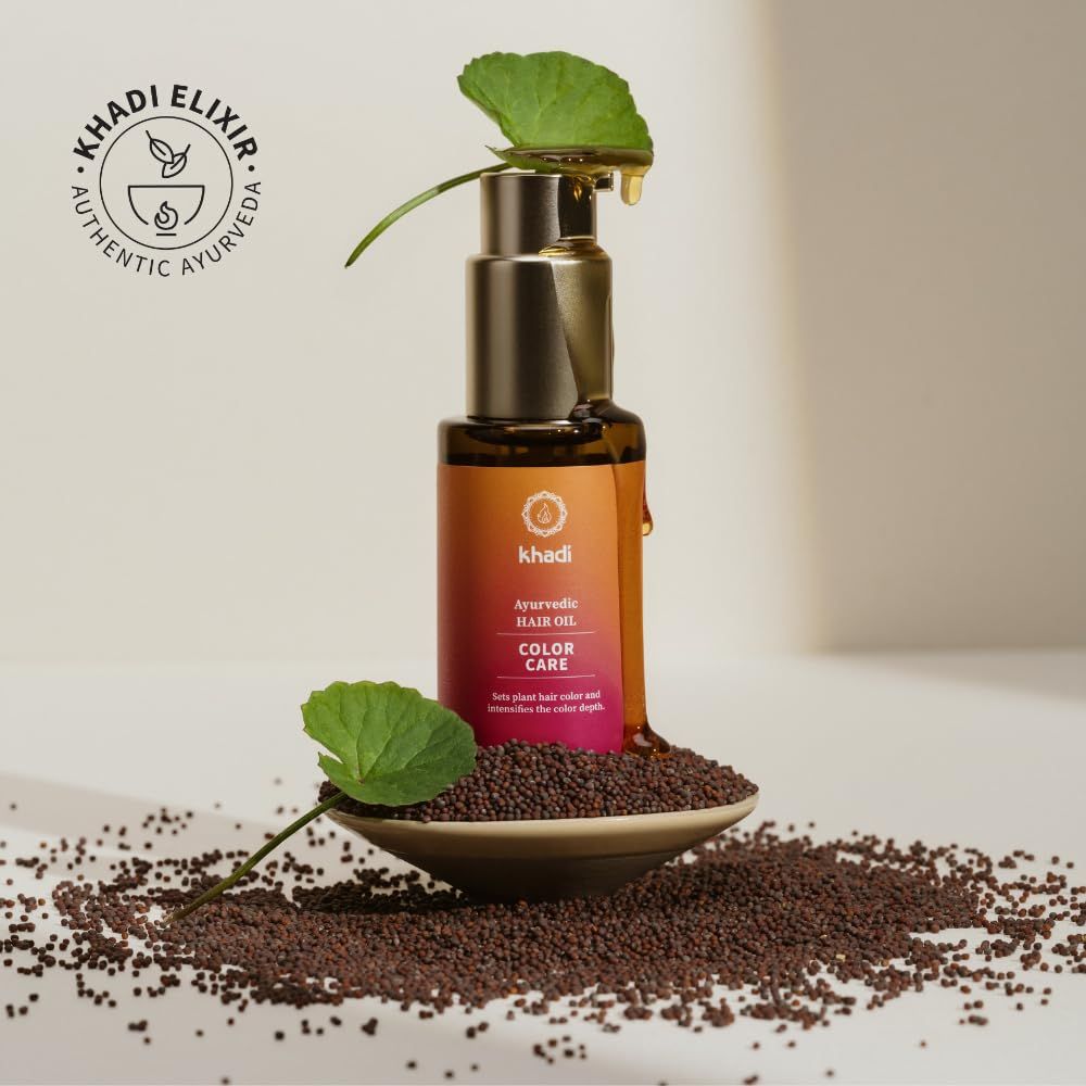 Flacone di vetro marrone con erogatore dorato. Etichetta con nome del prodotto e logo. Olio che gocciola. Foglie e semi.