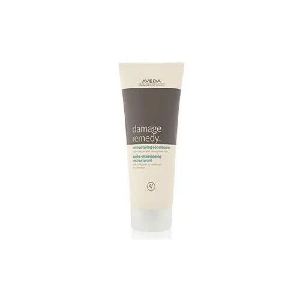 Tubo color crema con tappo grigio. Scritta: Damage Remedy Restructuring Conditioner. Marca: Aveda.