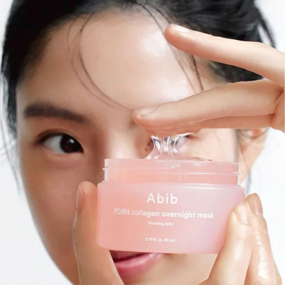 Vasetto rosa con gel trasparente. Scritta: Abib PDRN collagen overnight mask. Una mano tiene il gel.