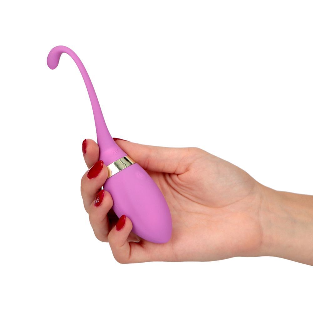 Mano che tiene un vibratore viola. Il vibratore ha una forma curva e un bordo dorato.