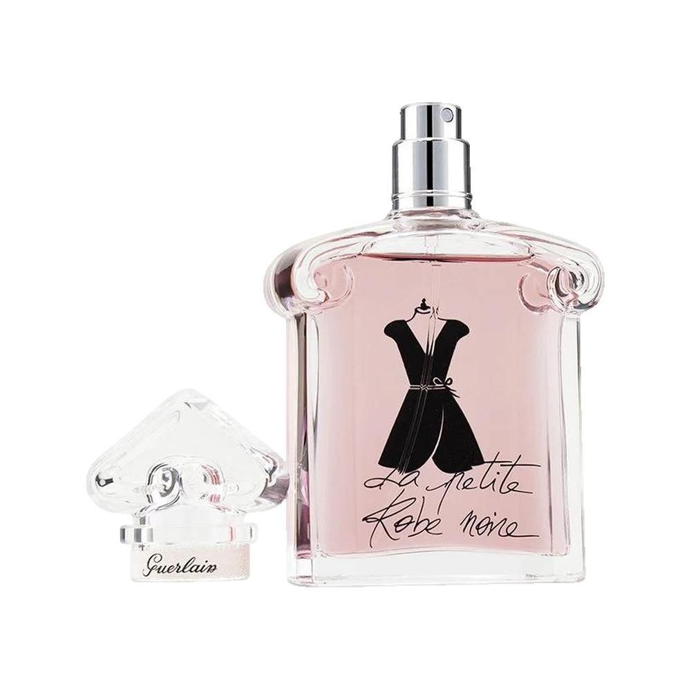 Flacone Guerlain con liquido rosa e design abito nero. Tappo trasparente accanto. Vaporizzatore argentato.