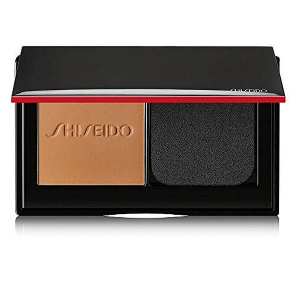 Cipria compatta con spugna. Custodia nera con dettaglio rosso. Marchio Shiseido visibile.