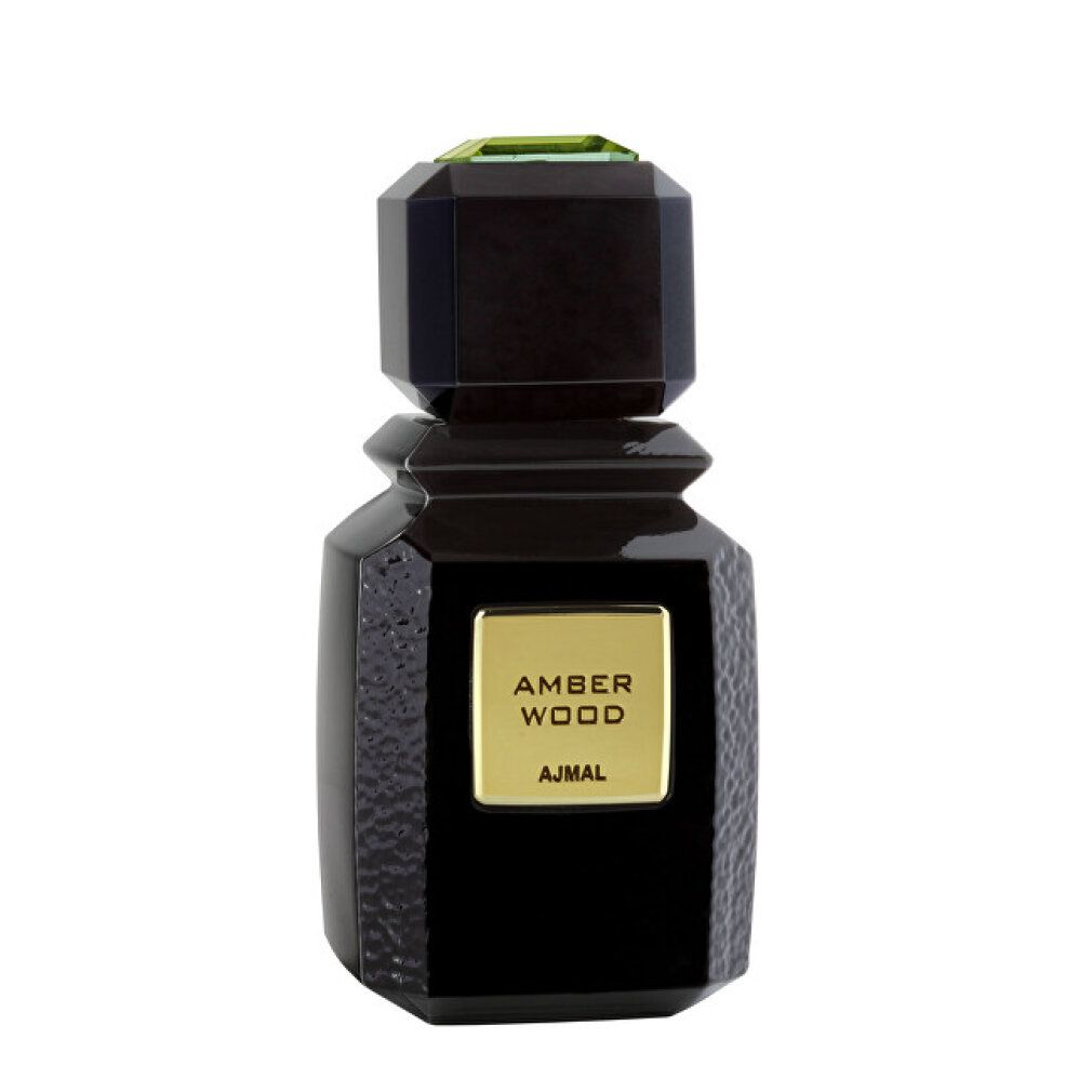 Flacone nero con etichetta dorata AMBER WOOD e AJMAL. Tappo angolare con ornamento verde.