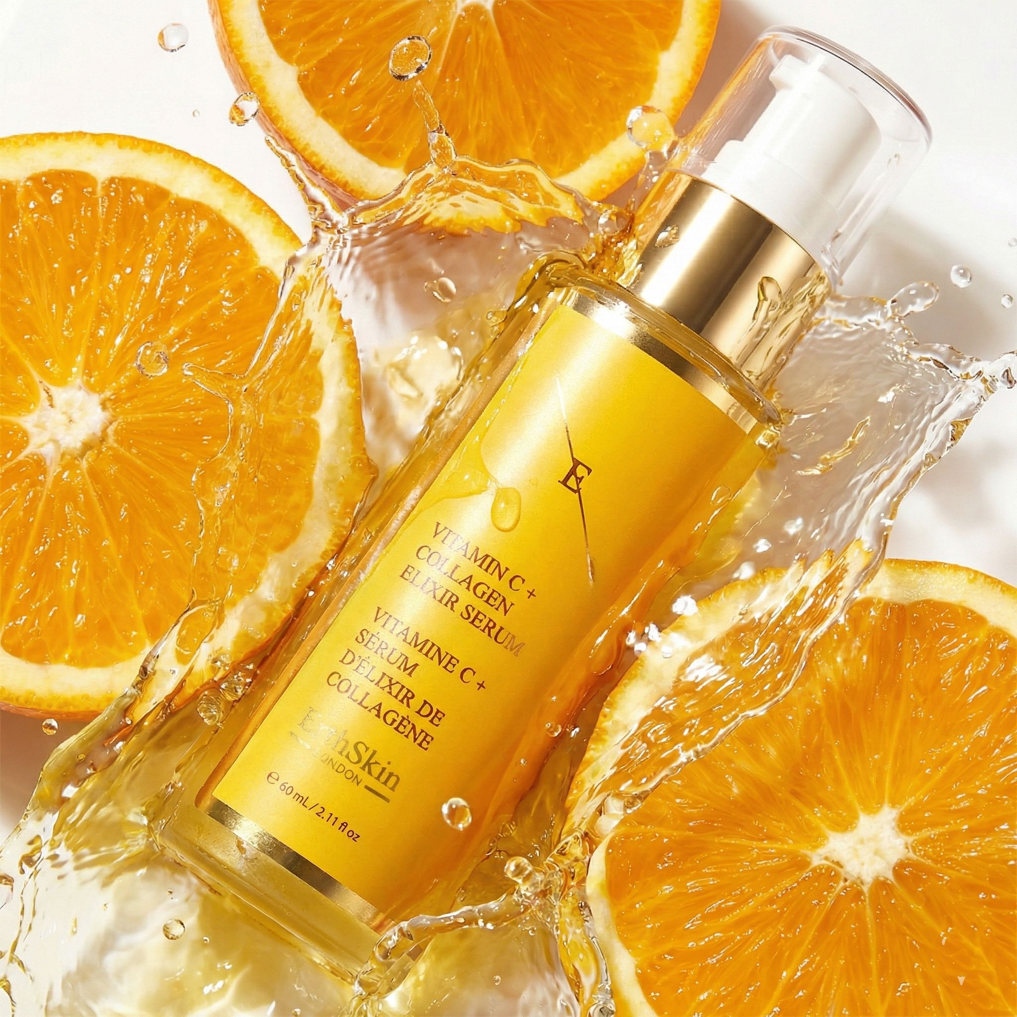 Flacone ErthSkin Vitamina C + Collagene Elixir Serum circondato da schizzi d'acqua e spicchi d'arancia.