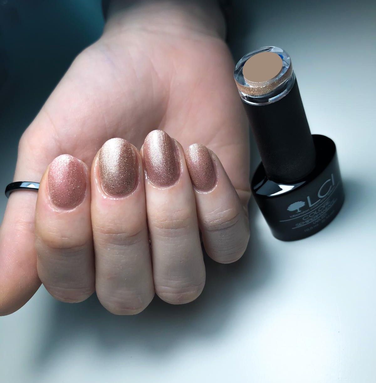 Mano con unghie smaltate oro, accanto flacone di smalto. Scritta: LCI, Colore Semipermanente, UVLED.