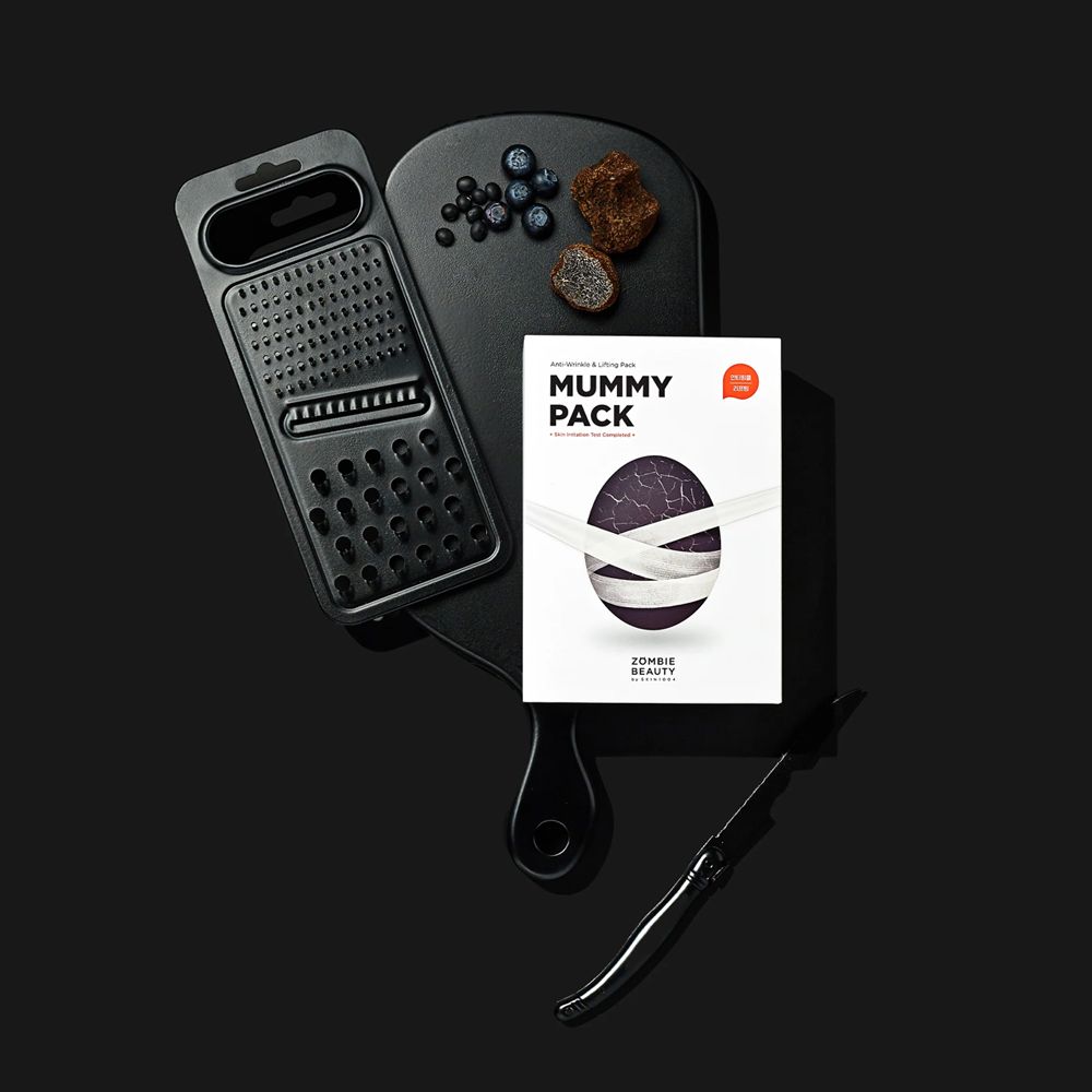 Tagliere nero con ingredienti e confezione prodotto. Scritta: MUMMY PACK.