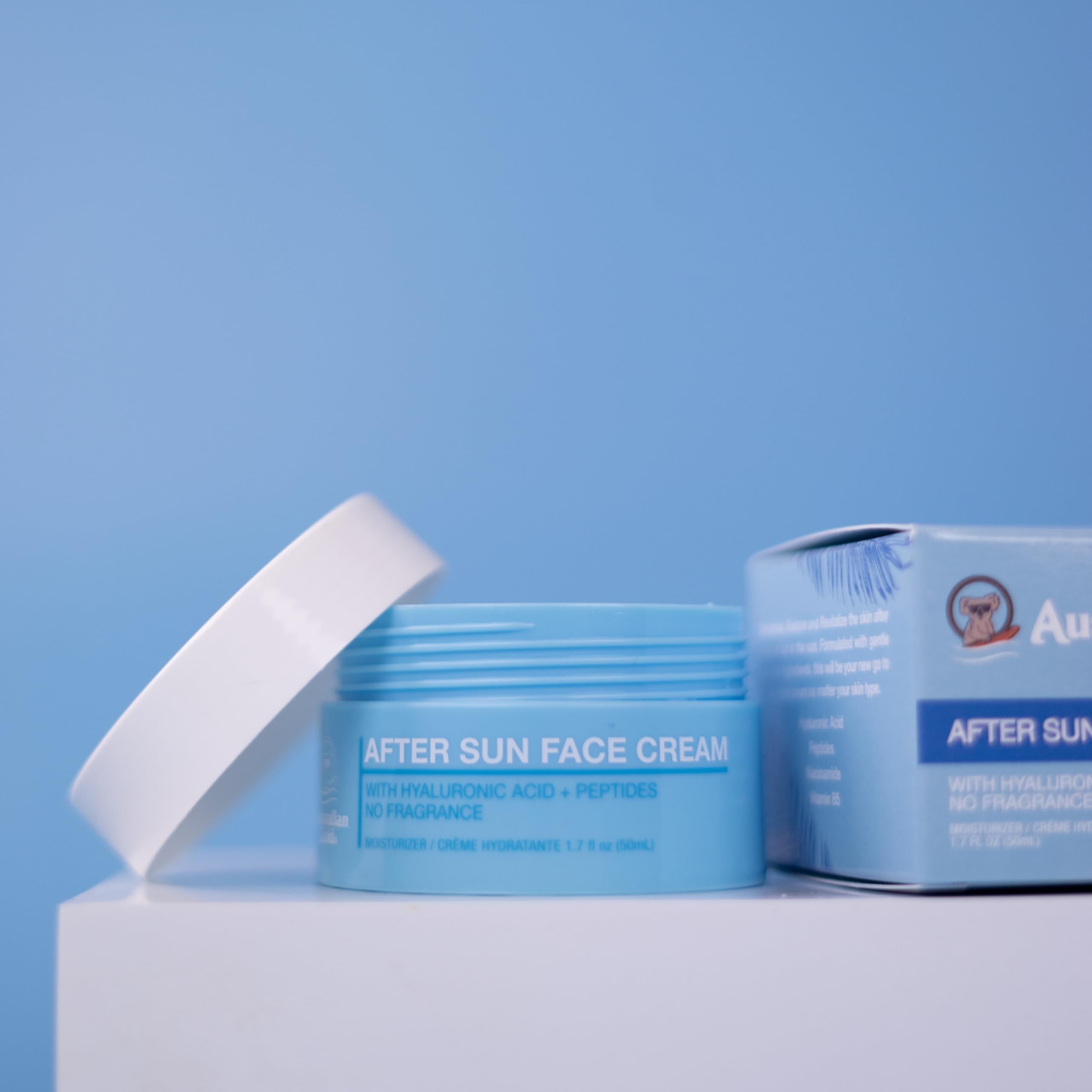 Barattolo di crema viso blu e bianco con coperchio aperto e scatola accanto. Testo: After Sun Face Cream. Marchio: Australian Gold.