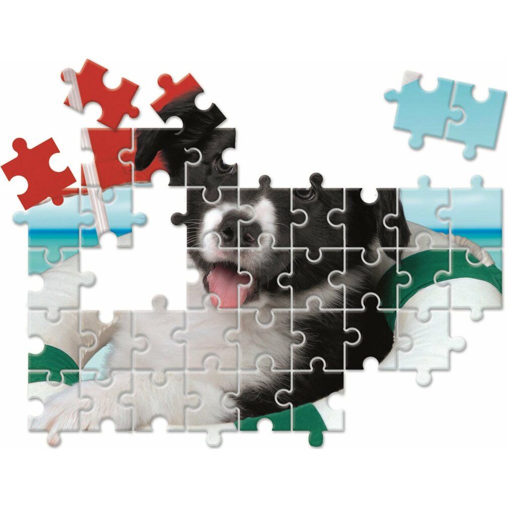 Un pezzo di puzzle con motivo cane, parzialmente assemblato. Singoli pezzi di puzzle accanto. Senza nome del prodotto.