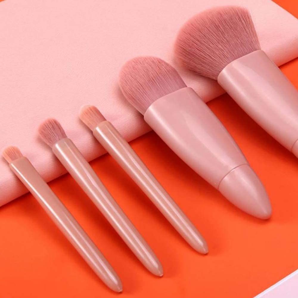 Cinque pennelli da trucco rosa di varie dimensioni e setole.