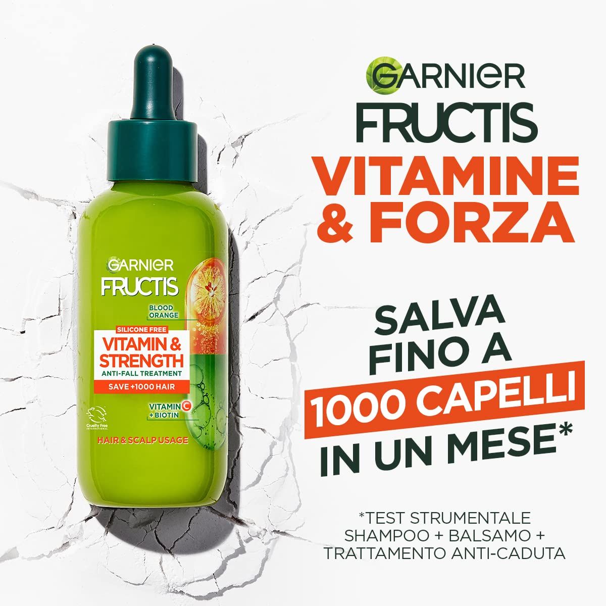 Flacone verde con contagocce. Scritta: Garnier Fructis Vitamine & Forza. Trattamento anticaduta. Contiene Vitamina C & Biotina.