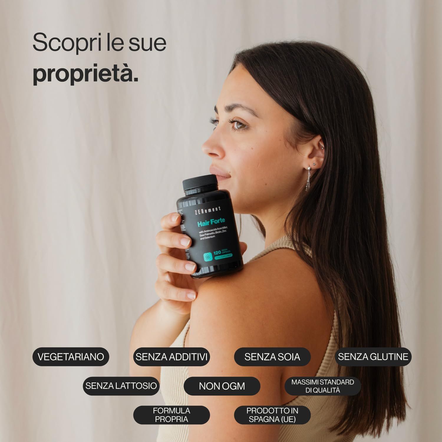 Donna che tiene in mano una bottiglia di Zenement Hair Forte. Sulla bottiglia c'è scritto Hair Forte e altre informazioni. Adesivi: vegetariano, senza additivi, senza soia, senza glutine.
