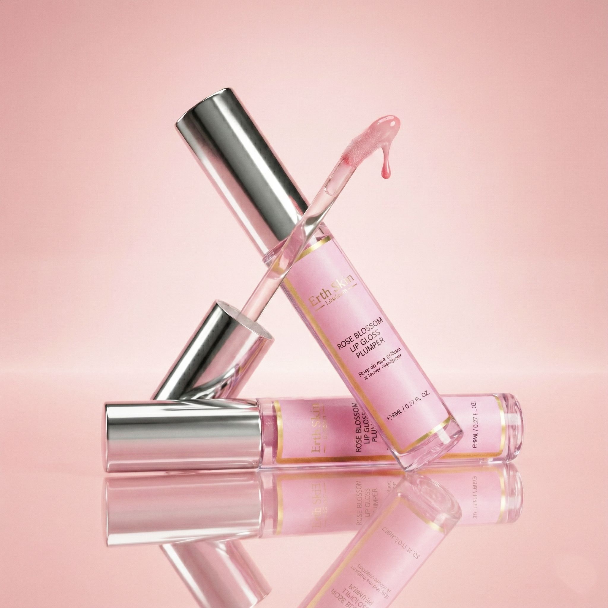 Due lucidalabbra con tappi argentati. Liquido rosa. Uno sdraiato, uno in piedi. Sfondo rosa.