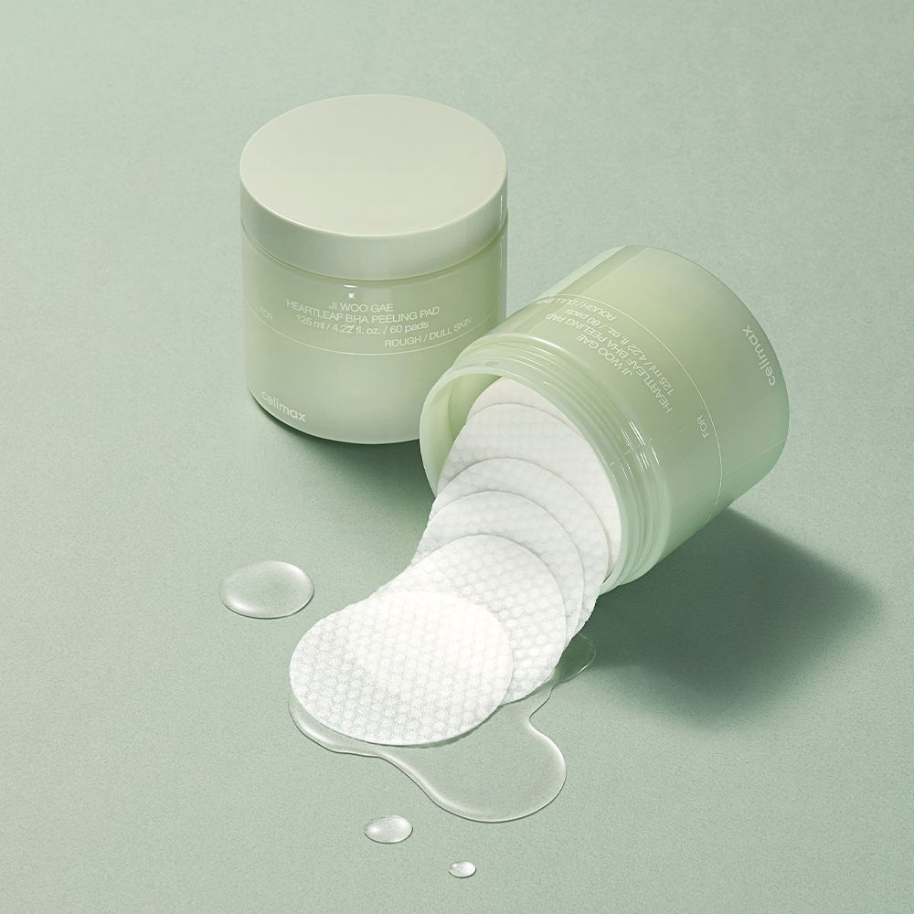 Un contenitore aperto con Celimax Heartleaf BHA Peeling Pads e liquido versato.