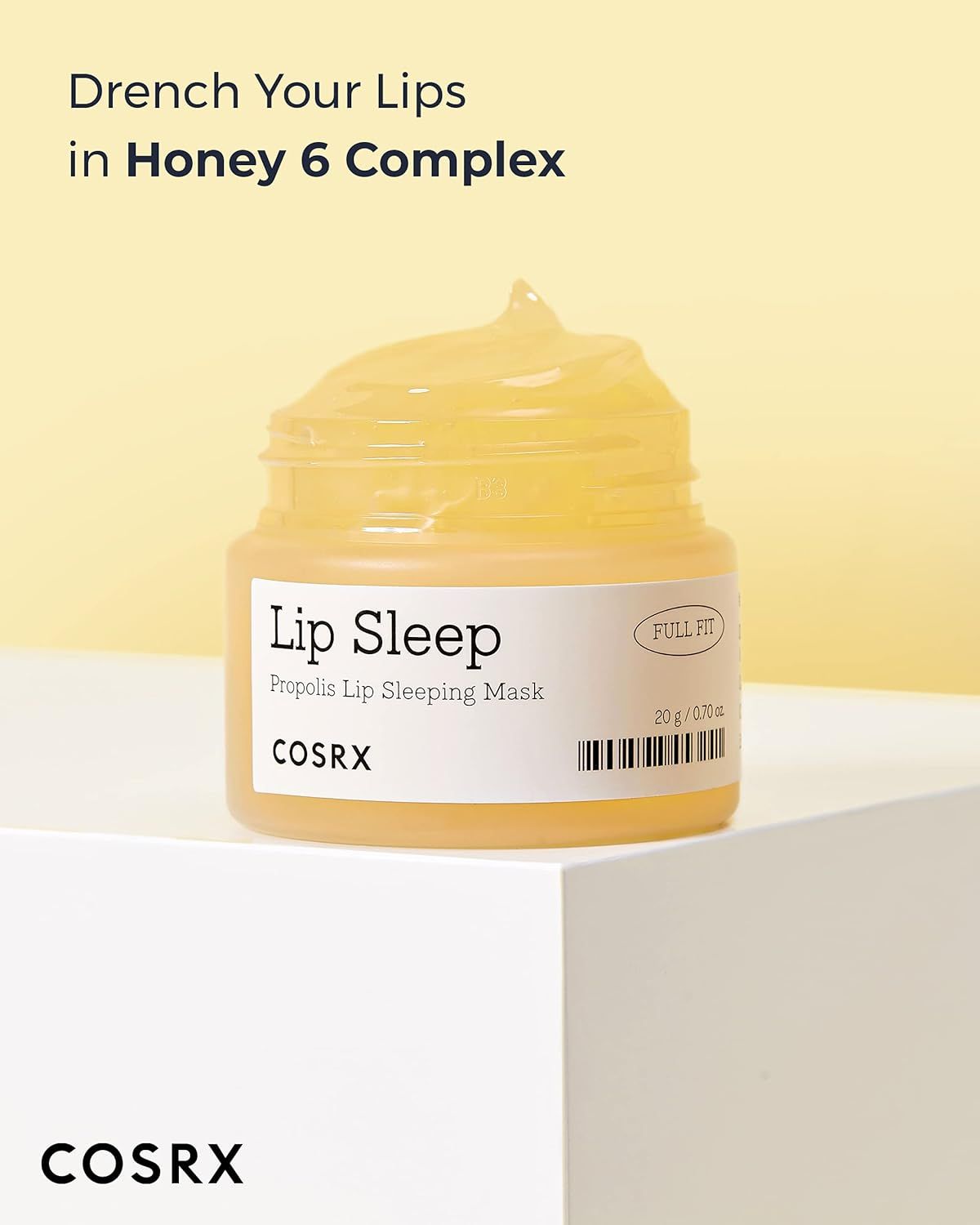 Vasetto di balsamo giallo su piedistallo bianco. Testo: "Lip Sleep", "COSRX".