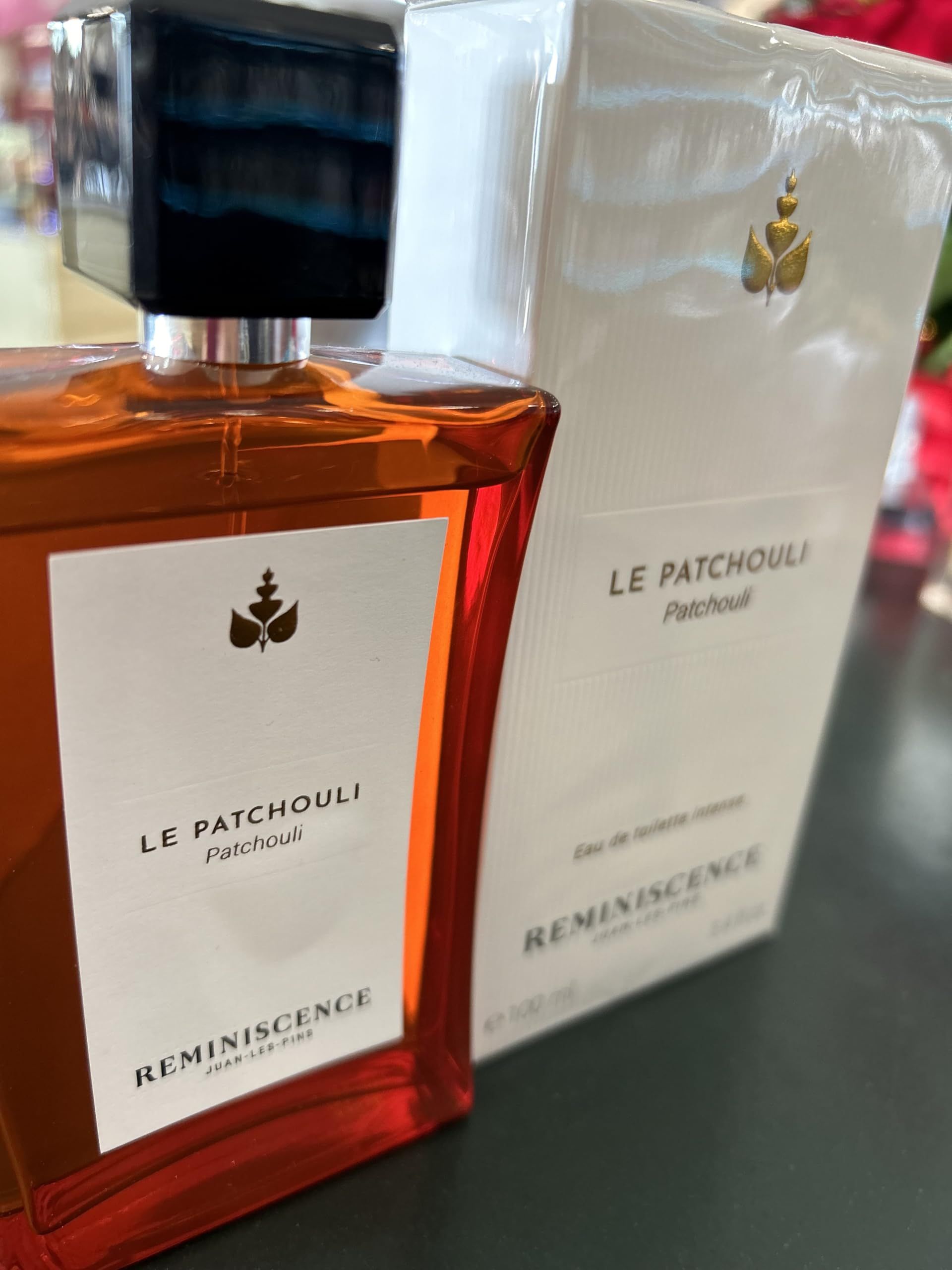 Flacone e confezione di Le Patchouli. Flacone rettangolare con tappo nero. Confezione bianca con logo e nome del prodotto.